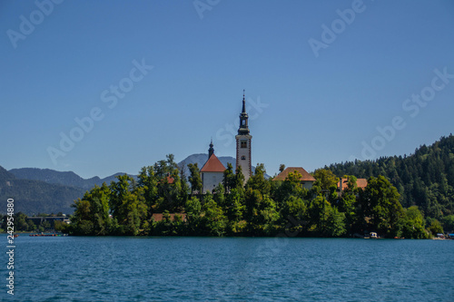 Iconic landscape view of beautiful  St. Marys Church of Assumption on small island,lake Bled in Slovenia .Bled Castle on background. Summer scene travel Slovenia concept. Tourist popular attraction © Dajahof