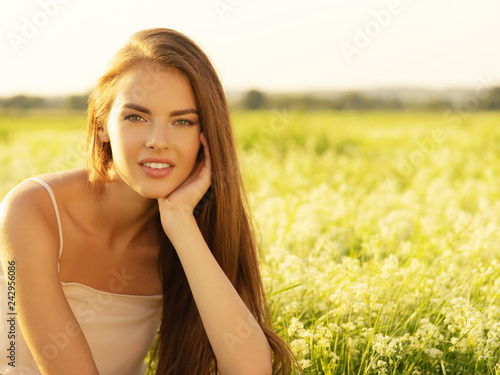 Beautiful young woman on nature over summer field background
