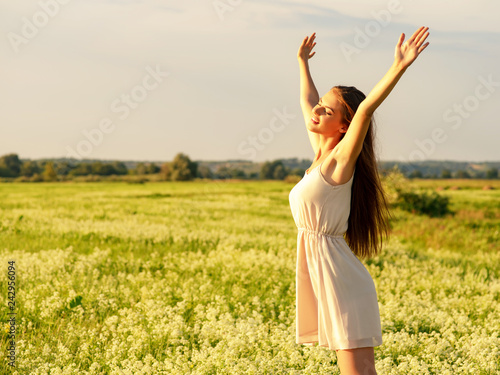 Happy and serene behavior woman outdoor with raised hands.