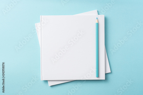 Top view of white hardcover notebook on blue