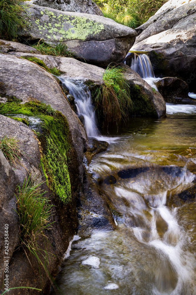 small rapid waterfalls created by a river when passing between stones small rapid waterfalls created by a river when passing between stones