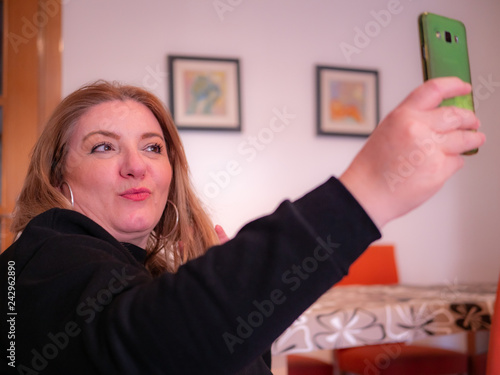 Middle aged woman takes a photo with his mobile phone
