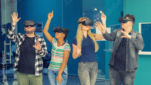 Multiracial friends group playing on vr glasses indoors. Virtual reality and wearable tech concept with young people having fun together connecting with headset goggles. Digital generation trends 