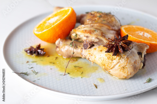 baked chicken with spices and tangerines close up.