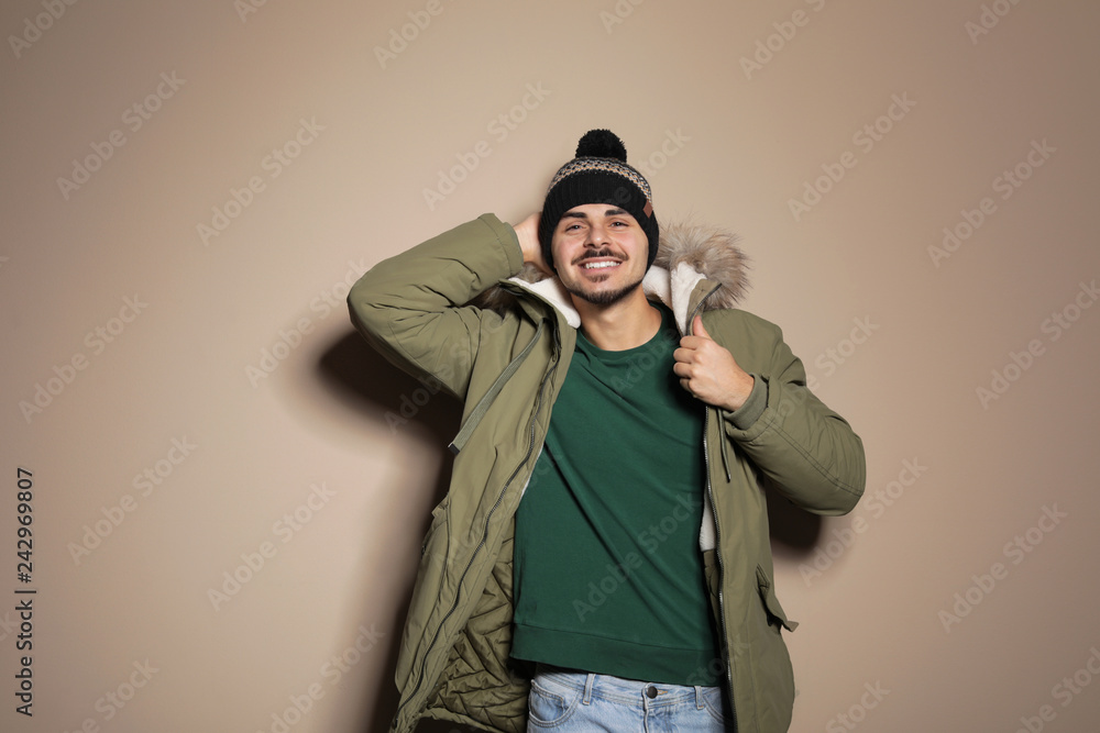 Young man wearing warm clothes on color background. Ready for winter vacation Young man wearing warm clothes on color background. Ready for winter vacation