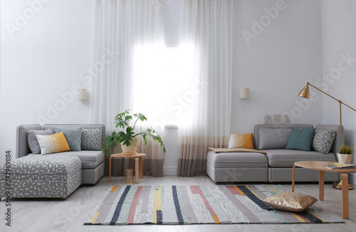 Modern living room interior with comfortable sofa near window © New Africa