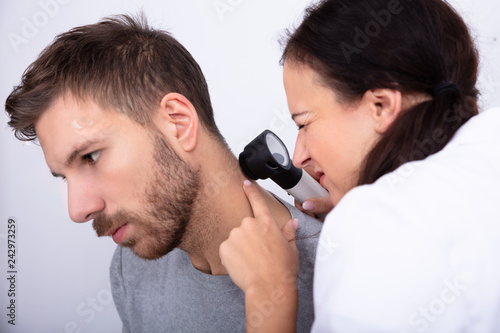 Doctor Checking Skin On Man's Neck