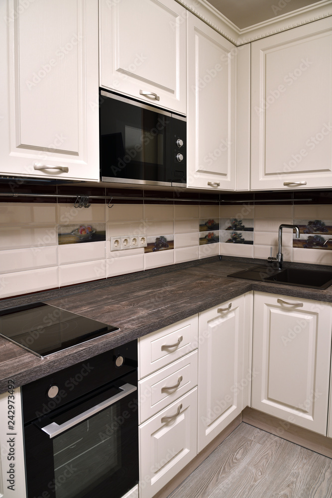 Fototapeta premium Beige kitchen with oven and a microwave