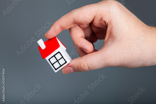 Man holds small house in hand