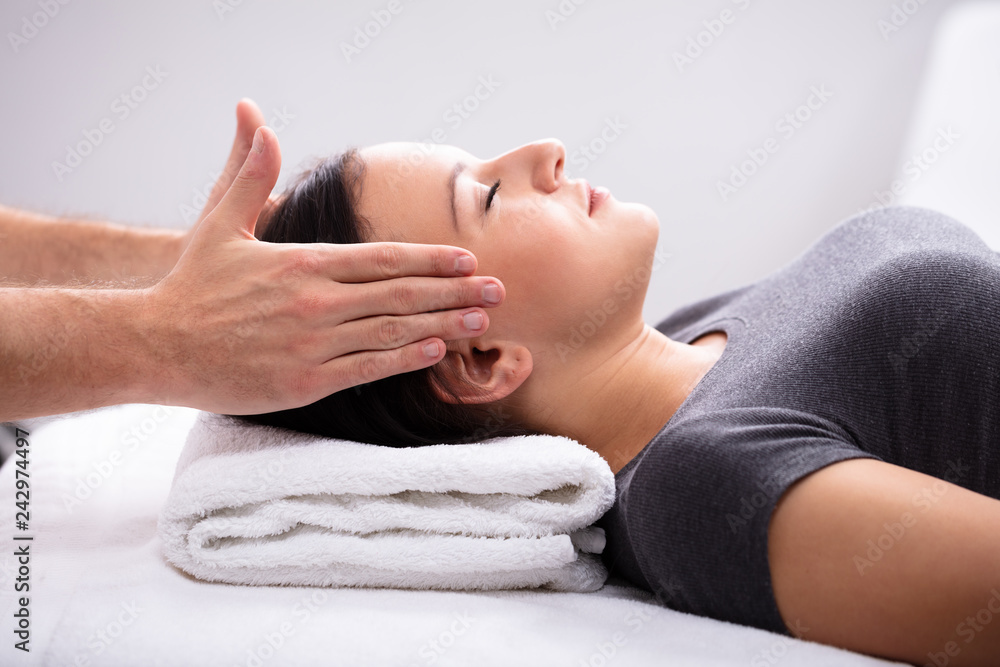 Therapist Giving Reiki Healing Treatment To Woman Therapist Giving Reiki Healing Treatment To Woman