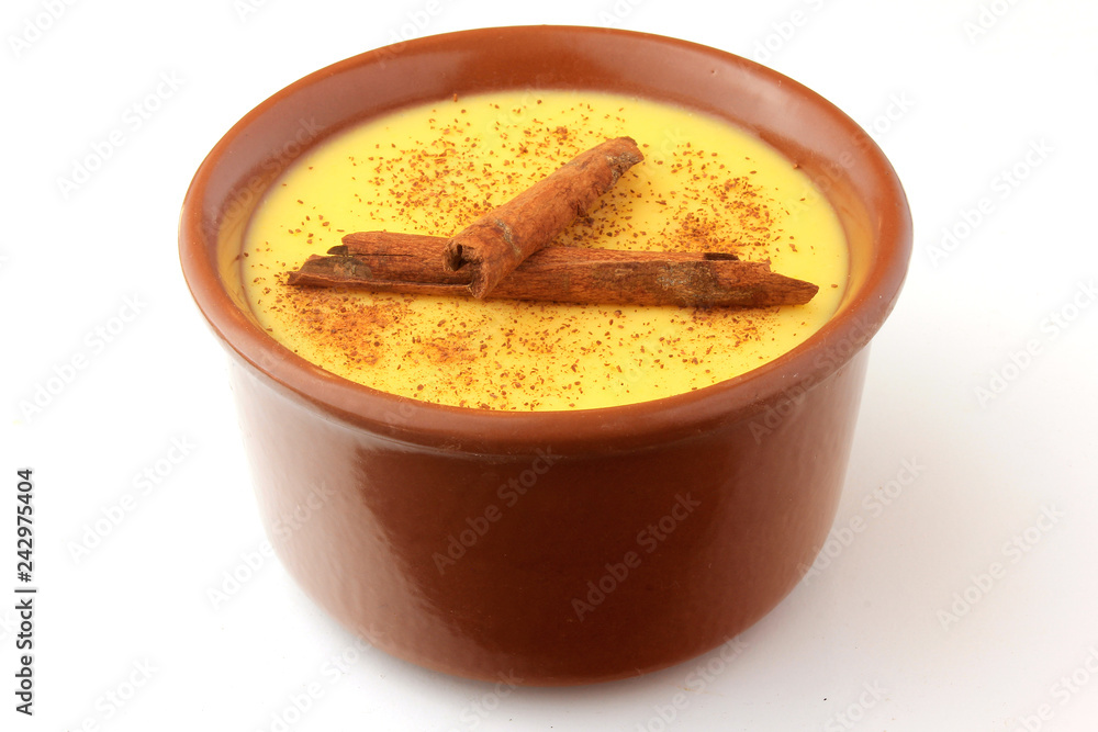 Curau, cream of corn sweet and dessert typical of the Brazilian cuisine, with cinnamon placed in ceramic bowl on white background. Copy space Curau, cream of corn sweet and dessert typical of the Brazilian cuisine, with cinnamon placed in ceramic bowl on white background. Copy space