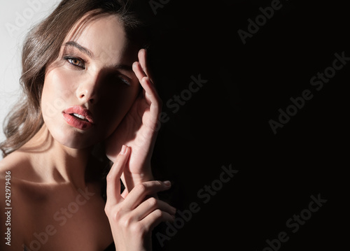 Beautiful portrait of a girl with hands on a black background