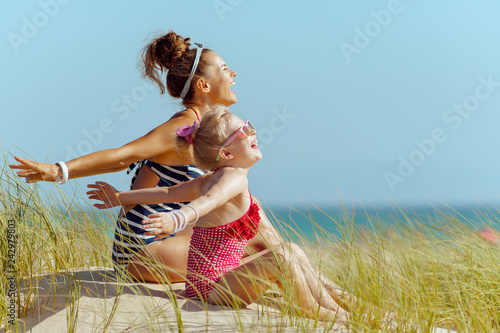Photography smiling young mother and child on seacoast rejoicing