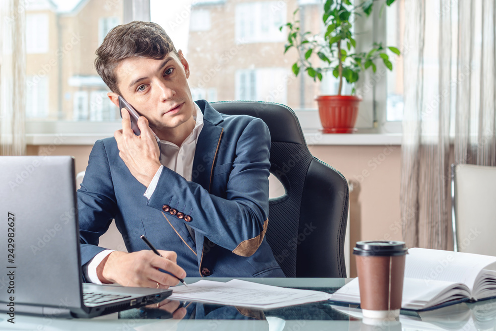 Naklejka premium Businessman sitting at the table signing documents in the office. Concept of transactions with securities
