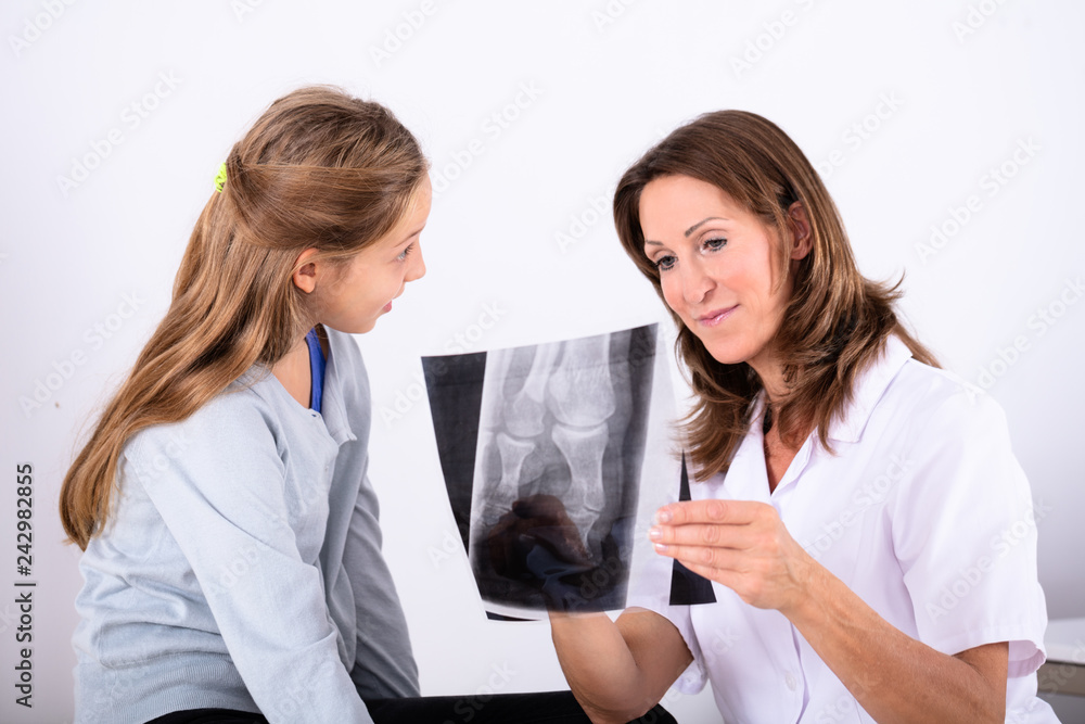 Girl Looking At Doctor Holding Bone X-ray