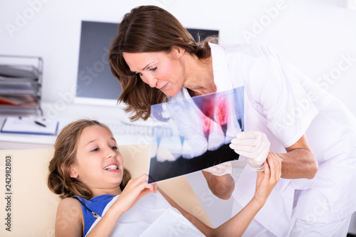 Dentist Showing Teeth X-ray To Girl