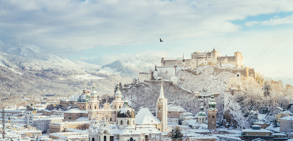 Naklejka premium Bird flying over Salzburg in winter: Snowy historical center, sunshine