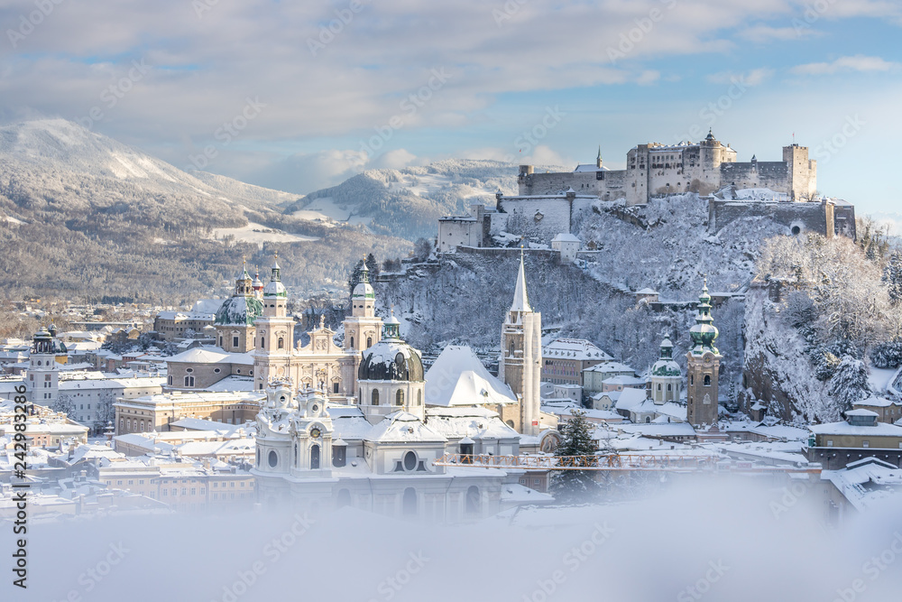 Fototapeta premium Panorama Salzburga zimą: zaśnieżone historyczne centrum, słońce