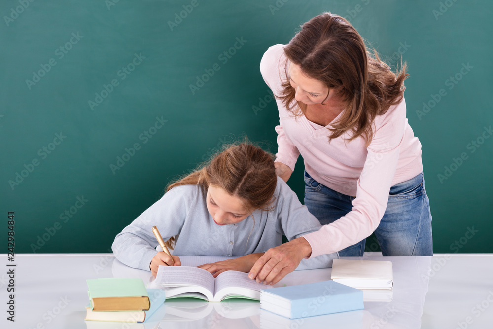 Teacher Looking At Student Doing Class Work Teacher Looking At Student Doing Class Work