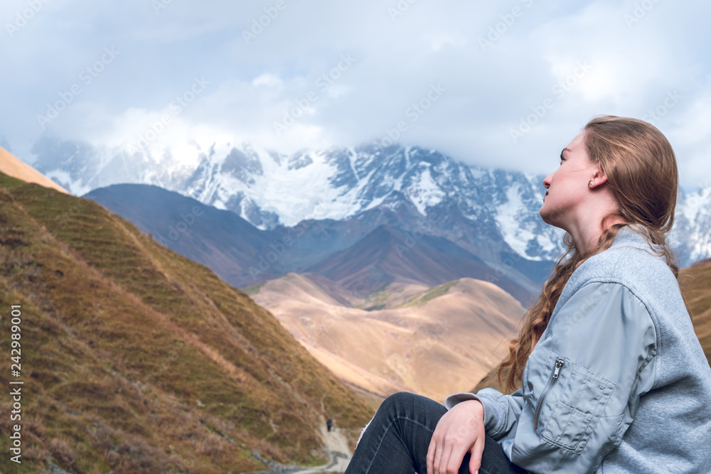 Beautiful girl on a mountain background of Svaneti, mountain Shkhara, relax while traveling.