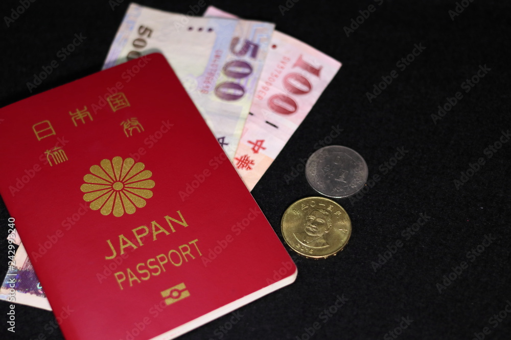 日本のパスポートと海外紙幣(台湾ドル) 黒背景 日本のパスポートと海外紙幣(台湾ドル) 黒背景