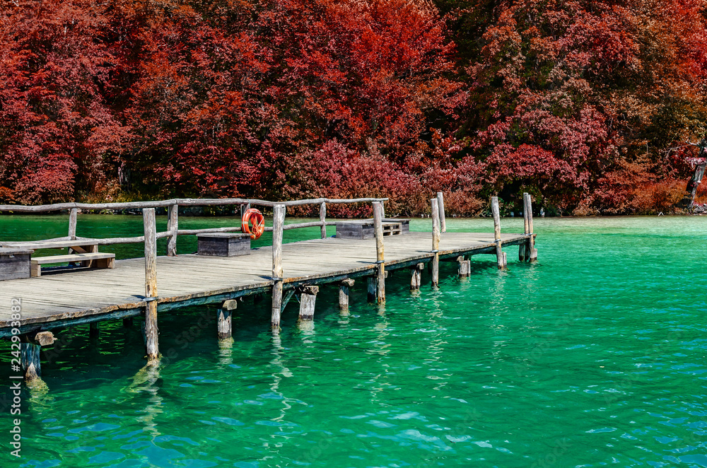 A wooden pier on a mountain lake with clear water.