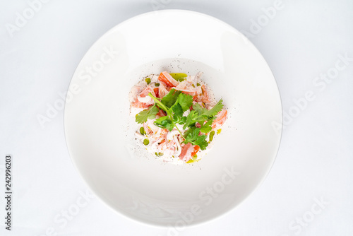 Tomato salad with onion and sour cream on the white plate - Image