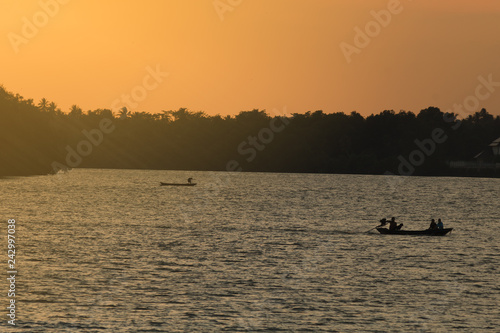 Longtail boat on river with golden evening light
