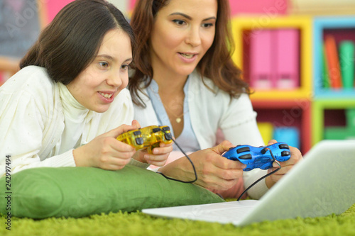 Portrait of happy mother and daughter playing game