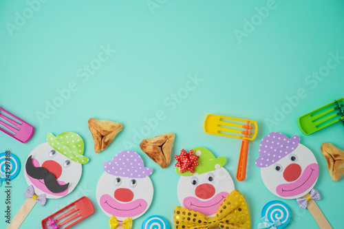 Jewish holiday Purim background with cute paper clowns characters and hamantaschen cookies.