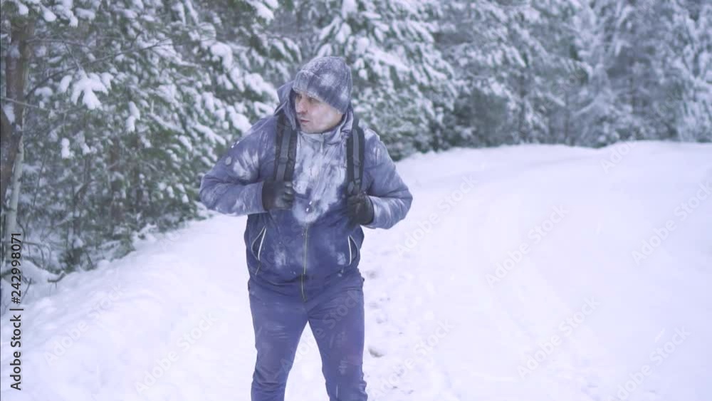 portrait frozen man in the snow, walking through the woods with a backpack portrait frozen man in the snow, walking through the woods with a backpack