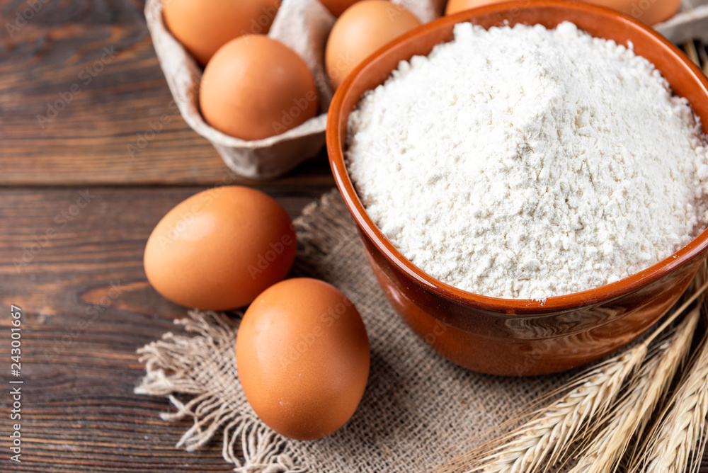 Flour and eggs on dark wooden table. Baking background. Flour and eggs on dark wooden table. Baking background.