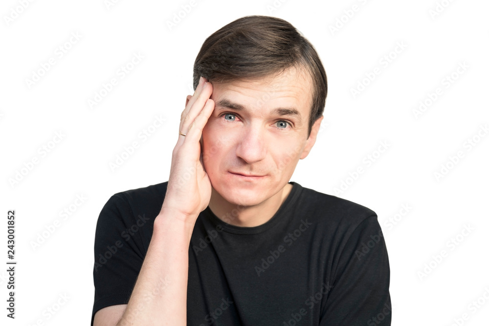 A man holds his head with a sad face on a white background. A man has a headache and he has a red, sick eye on conjunctivitis A man holds his head with a sad face on a white background. A man has a headache and he has a red, sick eye on conjunctivitis
