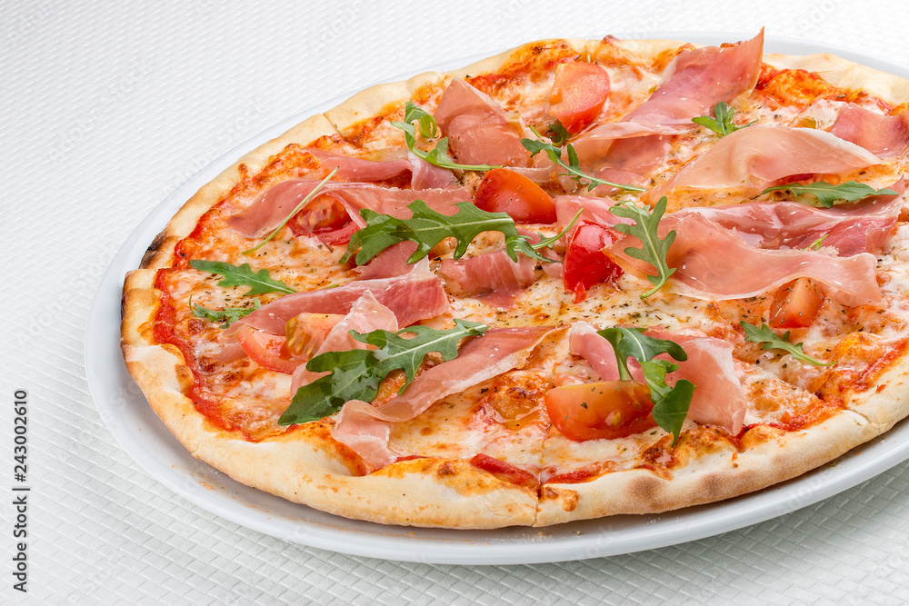 Pizza with prosciutto and arugula. On white background Pizza with prosciutto and arugula. On white background