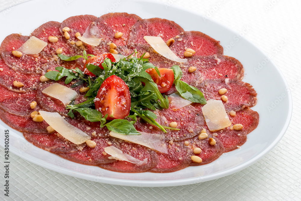 Tuna carpaccio with Parmesan cheese.  On white background