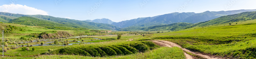 Panorama of a wide mountain valley on a sunny day
