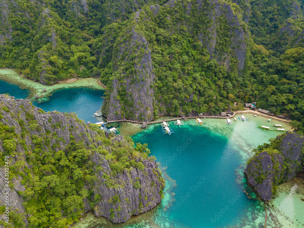 Aerial view to tropical lagoon with azure water and traditional sailing boats near Kayangan Lake, Coron island. Palawan, Philippines.