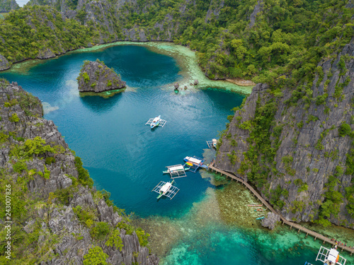 Aerial view to tropical lagoon with azure water and traditional sailing boats near Kayangan Lake, Coron island. Palawan, Philippines.