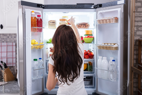 Tableau sur toile Woman Taking Food From Refrigerator