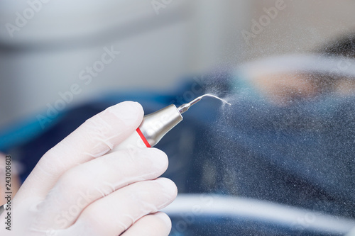 Dental ultrasonic scaler with water splash on black background. Close up. - macro photography photo