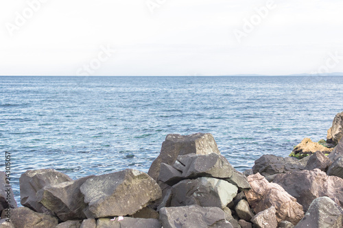 Multi-colored sea stones. Large stones in the sea or ocean. Seascape. Stone mound. The Black Sea coast in Nessebar. Nature of Bulgaria. Euro-trip. Cobblestones in the water.