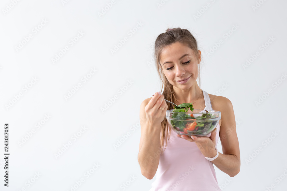People, food and diet concept - Portrait of woman eating healthy food over white background with copy space People, food and diet concept - Portrait of woman eating healthy food over white background with copy space
