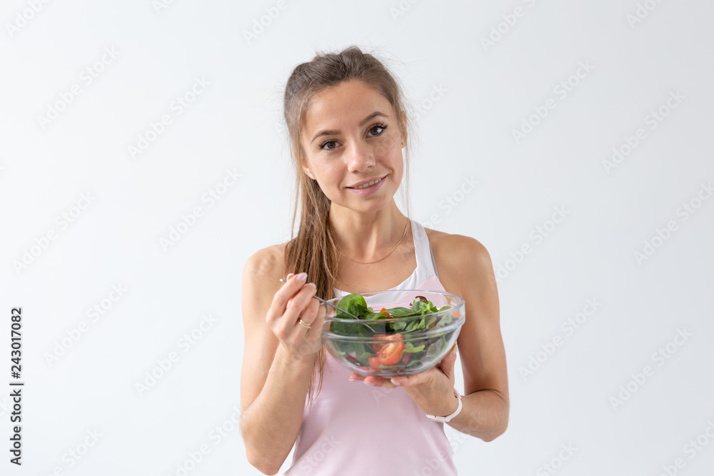 Healthy lifestyle, diet and people concept - young woman is eating a salad and smiling, because she likes healthy lifestyle Healthy lifestyle, diet and people concept - young woman is eating a salad and smiling, because she likes healthy lifestyle