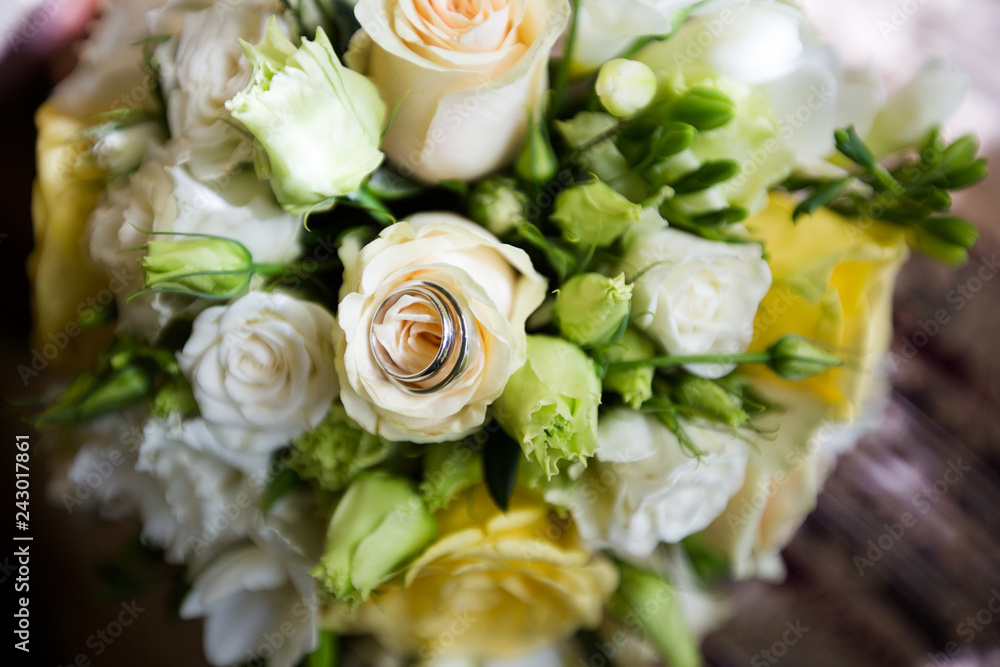 A pair of wedding rings on a bouquet of colorful flowers, close up shot A pair of wedding rings on a bouquet of colorful flowers, close up shot