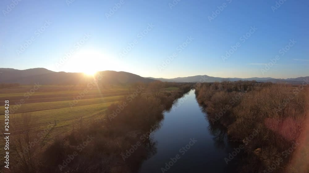 AERIAL Calm river running through the fields at sunset AERIAL Calm river running through the fields at sunset
