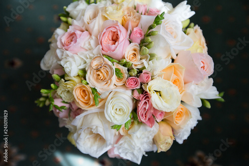 A pair of wedding gold rings on a bouquet of colorful flowers  close up shot