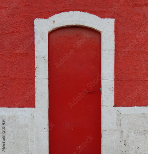 Red door with white frame in red wall  © David Jalda
