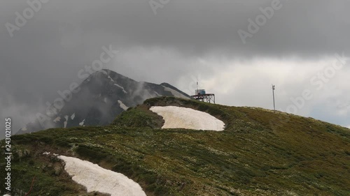 Grey clouds passing at mountain peak, timelaps photo