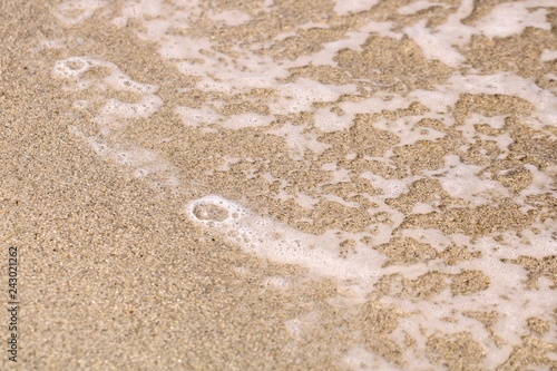 Ocean water bubbles on sandy shore in Hopkins, Belize