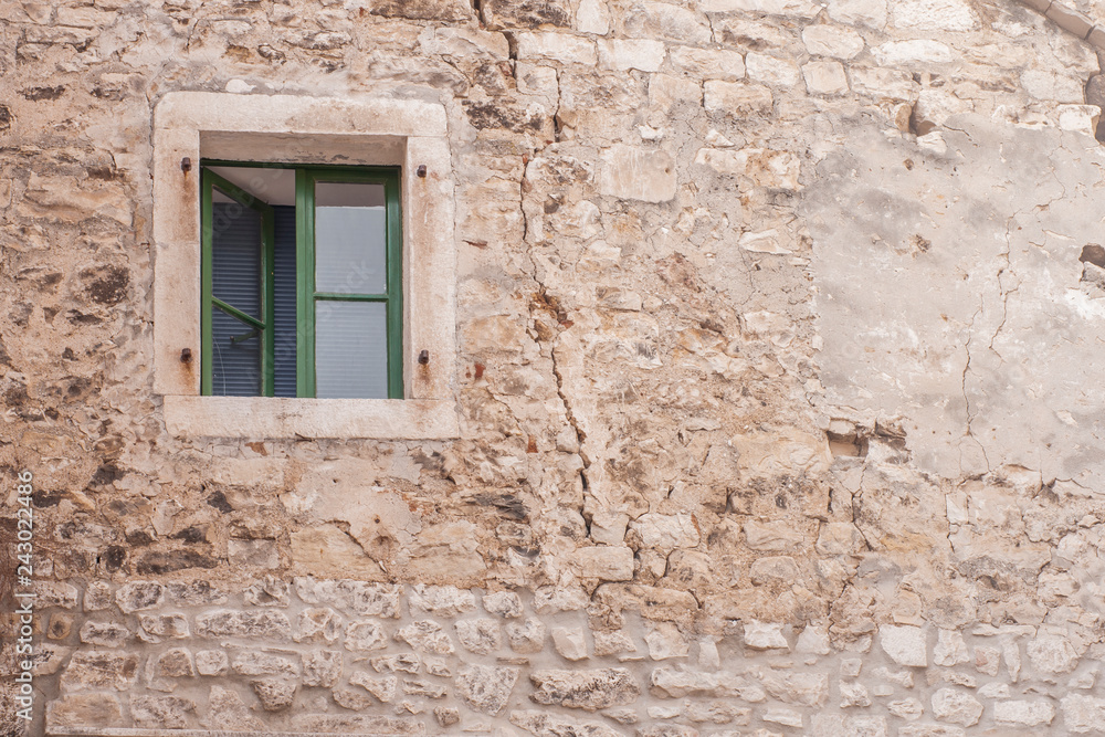 Green window on stone wall. Beautiful Mediterranean background. 